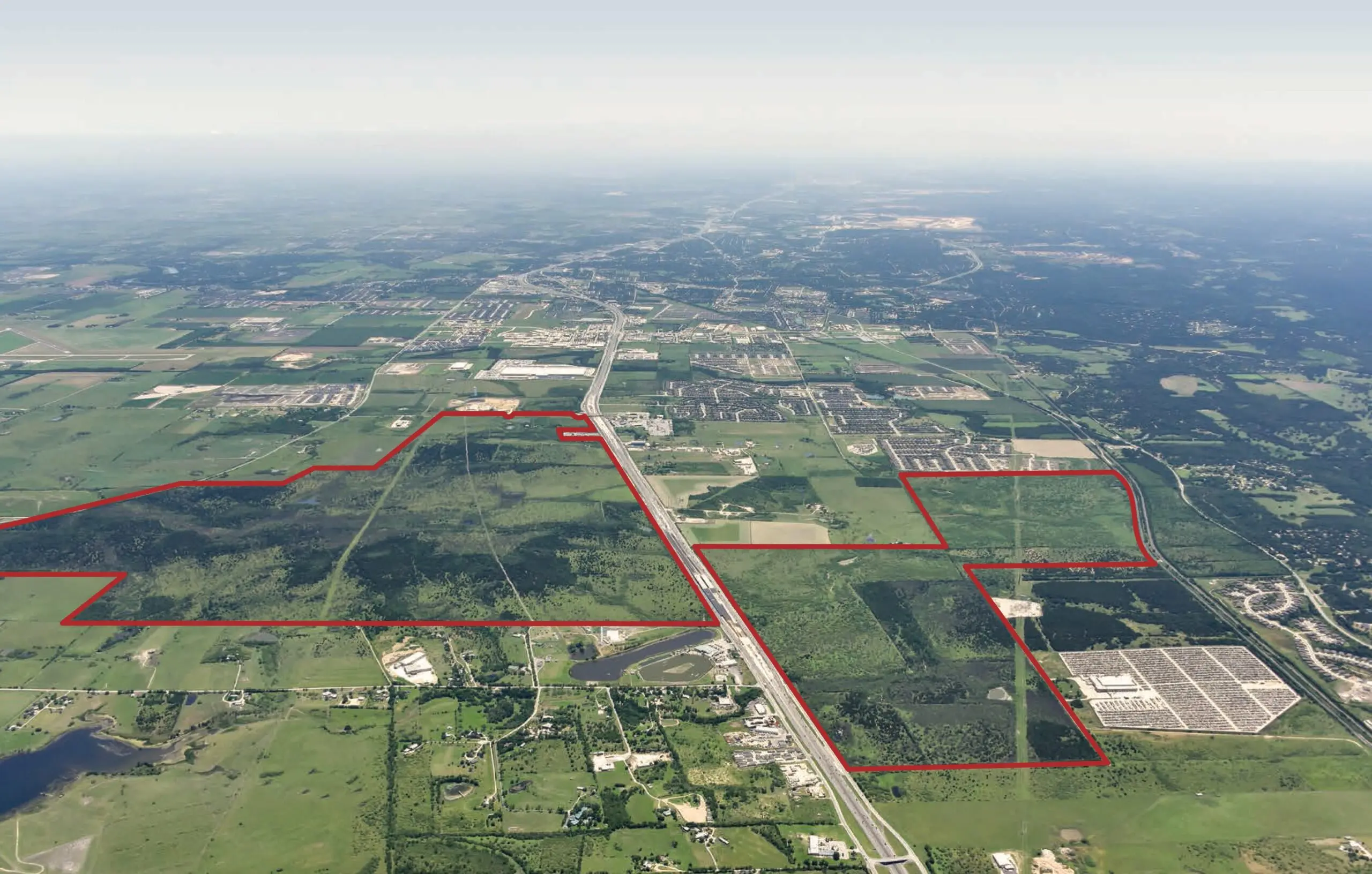 An aerial view of a large area of land with red lines outlining the Mayfair perimeter