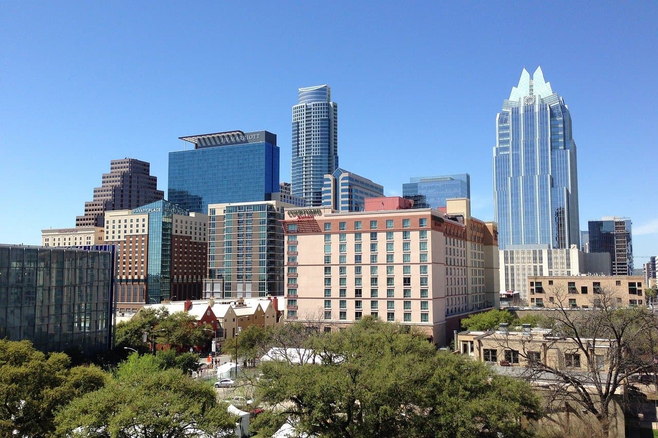 The Austin city skyline with tall buildings and trees.