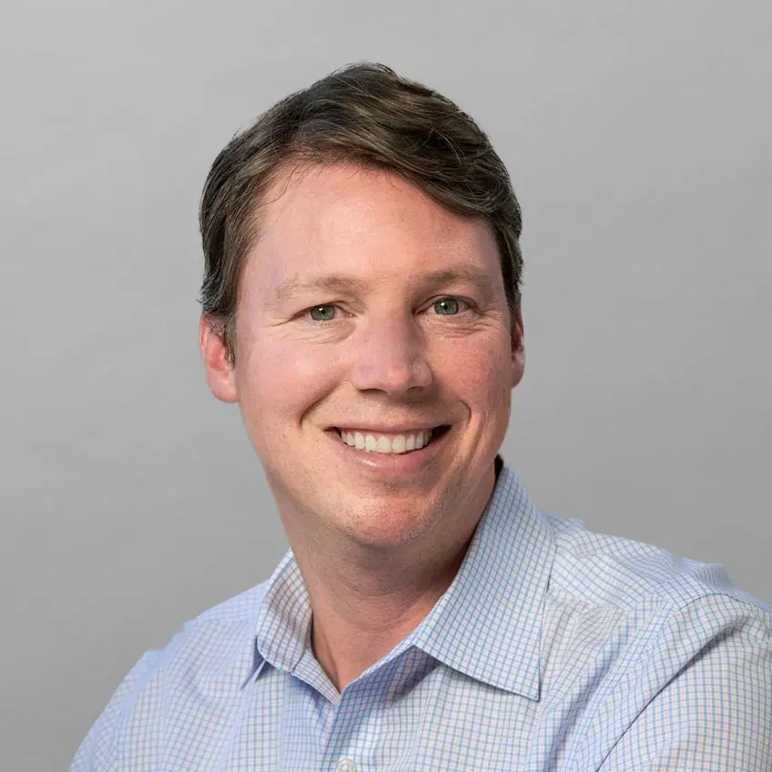 A smiling man in a blue shirt.