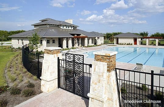 A swimming pool in front of a home at Woodcreek