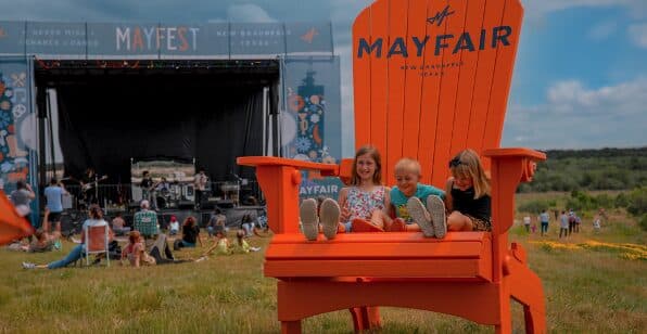 Children sit on an oversized chair.
